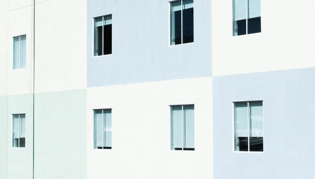 Clean white apartment building facade with square windows