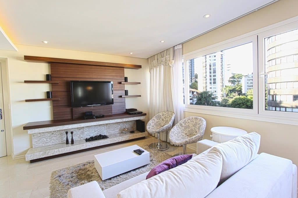 Apartment living room with a white sofa and wooden TV wall